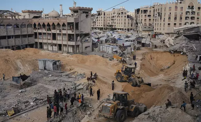Palestinians watch members of the Hamas militant group searching for bodies of the hostages in an area in Hamad City, Khan Younis, in the southern Gaza Strip, Saturday, Oct. 18, 2025. (AP Photo/Jehad Alshrafi)