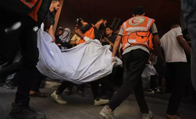 The bodies of Palestinians, killed by Israeli fire after crossing the ceasefire line according to the Hamas-run Civil Defense, are brought to Al Ahli Hospital in Gaza City, Saturday, Oct. 18, 2025. (AP Photo/Yousef Al Zanoun)