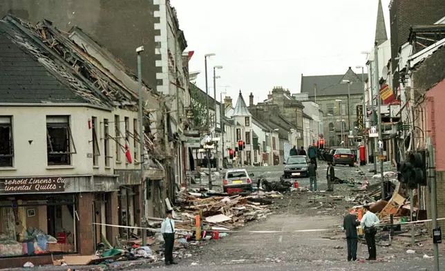 FILE - Royal Ulster Constabulary Police officers stand on Market Street, the scene of a car bombing in the centre of Omagh, Co Tyrone, 72 miles west of Belfast, Northern Ireland, on Aug. 15, 1998. (AP Photo/Paul McErlane, File)