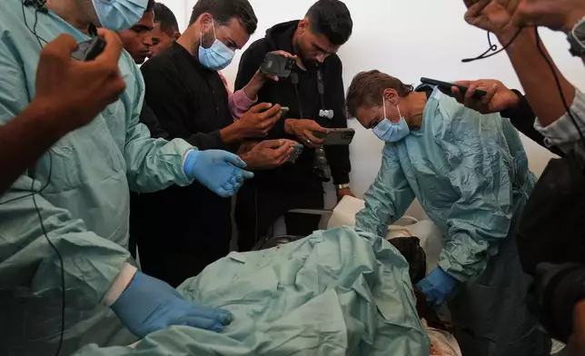 Palestinian doctors examine the bodies of Palestinians held by Israel during the war, as part of the identification process at Nasser Hospital in Khan Younis, southern Gaza Strip, Saturday, Oct. 18, 2025. (AP Photo/Abdel Kareem Hana)