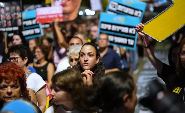 People listen to speeches as they take part in a rally demanding the returning of the bodies of hostages kidnapped by Hamas who are still in Gaza Strip, at a plaza known as hostages square, in Tel Aviv, Israel, Saturday, Oct. 18, 2025. (AP Photo/Francisco Seco)