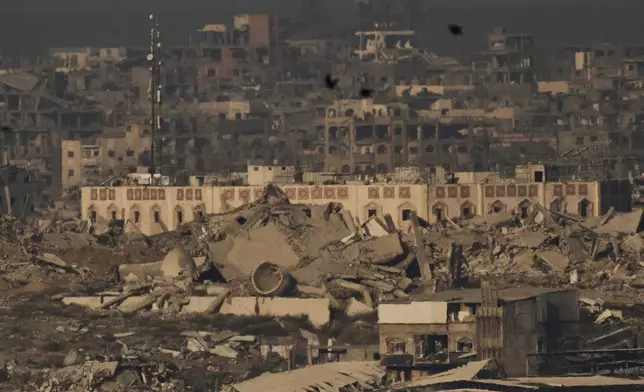 Buildings that were destroyed during the Israeli ground and air operations stand in the northern Gaza Strip during the sunrise, as seen from southern Israel, Friday, Oct. 17, 2025. (AP Photo/Leo Correa)