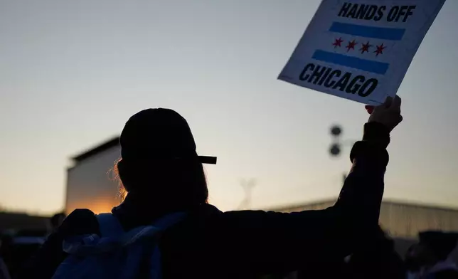 A protester holds a sign outside an ICE processing facility in the Chicago suburb of Broadview, Ill., Friday, Oct. 31, 2025. (AP Photo/Nam Y. Huh)