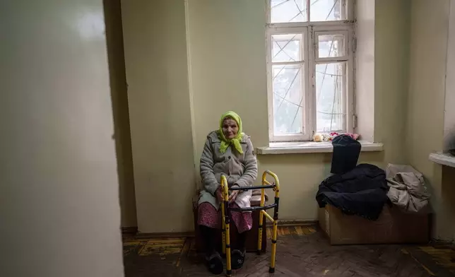 Oleksandra Bezshapko, 91, sits in the corridor of a hostel for displaced people in Dnipro, Ukraine, Wednesday, Oct. 8, 2025. (AP Photo/Evgeniy Maloletka)