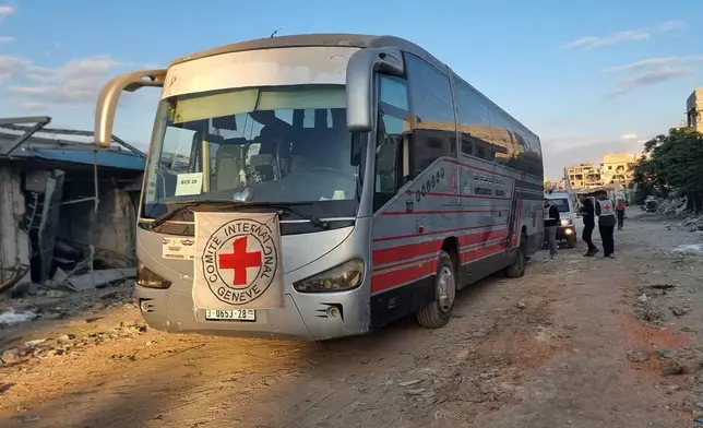 Red Cross vehicles and buses stand by in Khan Younis, southern Gaza Strip, on Monday, Oct. 13, 2025, ahead of the release of Palestinian prisoners by Israel. (AP Photo/Mohammad Jahjouh)