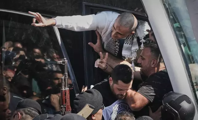 Palestinian prisoners wave to the crowd after being released from Israeli prison following a ceasefire agreement between Israel and Hamas, in the West Bank city of Ramallah, Monday, Oct. 13, 2025. (AP Photo/Mahmoud Illean)