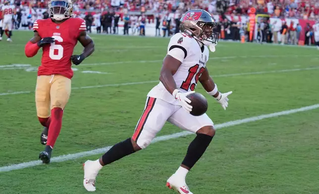 Tampa Bay Buccaneers wide receiver Kameron Johnson, right, celebrates after scoring past San Francisco 49ers safety Malik Mustapha (6) during the first half of an NFL football game in Tampa, Fla., Sunday, Oct. 12, 2025. (AP Photo/Chris O'Meara)