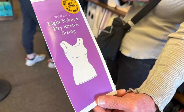 A woman holds a pamphlet for the new sleeveless sacred garments worn by members of The Church of Jesus Christ of Latter-day Saints at Deseret Book in Salt Lake City on Tuesday, Oct. 28, 2025. (AP Photo/Hannah Schoenbaum)