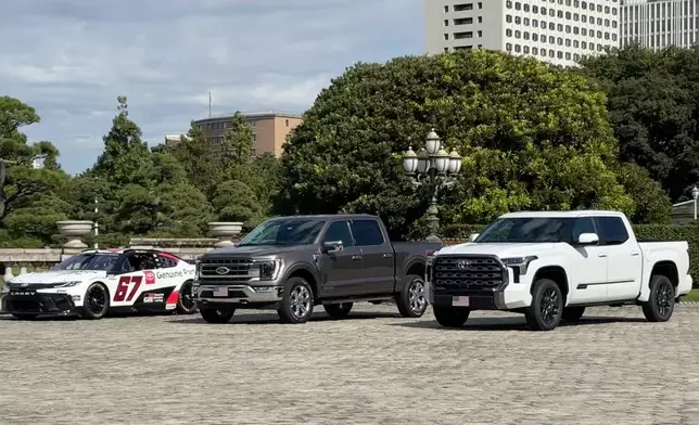 In this image made from video, A Ford F-150, center, and two other American-made cars sit parked outside Akasaka Palace, in Tokyo, Japan, Tuesday, Oct. 28, 2025, as President Donald Trump meets Japan's Prime Minister Sanae Takaichi. (AP Photo/Mayuko Ono)