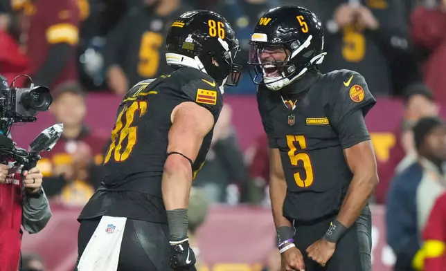 Washington Commanders tight end Zach Ertz (86) and quarterback Jayden Daniels (5) celebrate connecting for a touchdown during the second half of an NFL football game Monday, Oct. 13, 2025, in Landover, Md. (AP Photo/Stephanie Scarbrough)