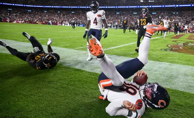 Washington Commanders safety Quan Martin (20) rolls through the play Chicago Bears quarterback Caleb Williams (18) as Williams scores a touchdown during the first half of an NFL football game Monday, Oct. 13, 2025, in Landover, Md. (AP Photo/Nick Wass)
