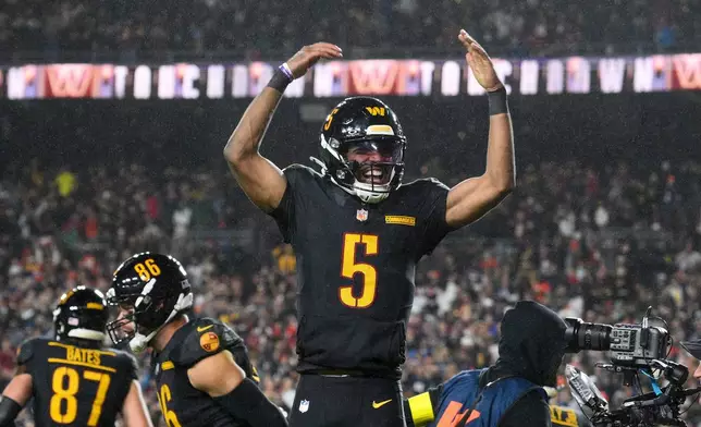 Washington Commanders quarterback Jayden Daniels (5) celebrates a touchdown pass during the second half of an NFL football game against the Chicago Bears, Monday, Oct. 13, 2025, in Landover, Md. (AP Photo/Nick Wass)