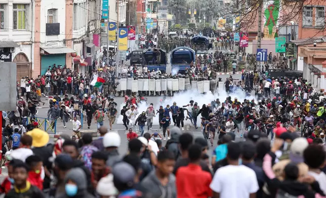 Demonstrators protesting against chronic electricity and water cuts confront riot police in Antananarivo, Madagascar, Tuesday, Sept. 30, 2025. (AP Photo/Mamyrael)