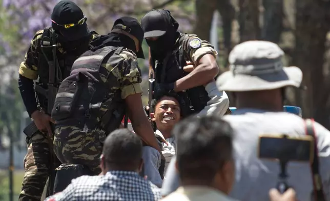 Police arrest a demonstrator during a protest calling for president to step down in Antananarivo, Madagascar, Thursday, Oct. 9, 2025. (AP Photo/Alexander Joe)