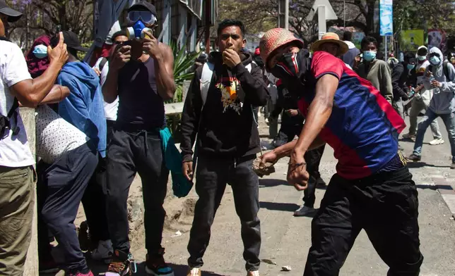 A man throws a stone during a protest calling for the president to step down in Antananarivo, Madagascar, Thursday, Oct. 9, 2025. (AP Photo/Alexander Joe)