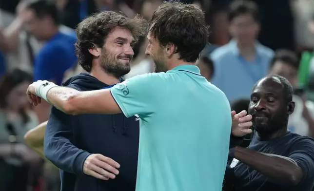 Arthur Rinderknech of France, right, is greeted by his cousin Valentin Vacherot of Monaco after defeating Daniil Medvedev of Russia in the men's singles semifinal match of the Shanghai Masters tennis tournament at Qizhong Forest Sports City Tennis Center, in Shanghai, China, Saturday, Oct. 11, 2025. (AP Photo/Andy Wong)