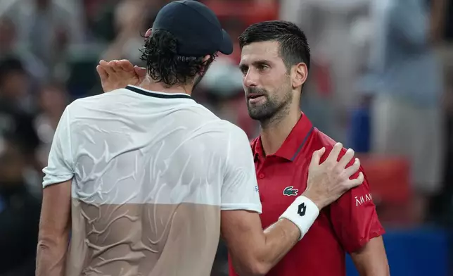 Valentin Vacherot of Monaco, left, is greeted by Novak Djokovic of Serbia after the former won in their men's singles semifinal match of the Shanghai Masters tennis tournament at Qizhong Forest Sports City Tennis Center, in Shanghai, China, Saturday, Oct. 11, 2025. (AP Photo/Andy Wong)