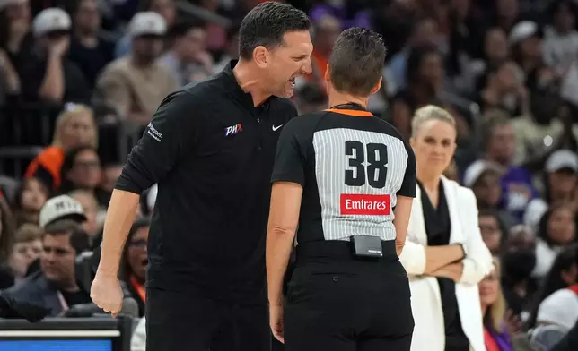 Phoenix Mercury head coach Nate Tibbetts, left, yells at official Lamont Simpson (38) after a foul during the second half of Game 4 of the WNBA basketball finals against the Las Vegas Aces, Friday, Oct. 10, 2025, in Phoenix. (AP Photo/Rick Scuteri)