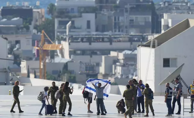 Nimrod Cohen, an Israeli hostage released from the Gaza Strip holds an Israeli flag after coming off a helicopter at the Ichilov Hospital, in Tel Aviv, Israel, Monday, Oct. 13, 2025. (AP Photo/Ohad Zwigenberg)