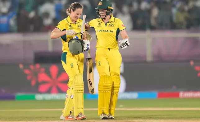 Australia's Ellyse Perry, left, and batting partner Kim Garth celebrate after their win in the ICC Women's Cricket World Cup match against India at ACA-VDCA Cricket Stadium in Visakhapatnam, India, Sunday, Oct. 12, 2025. (AP Photo/Aijaz Rahi)
