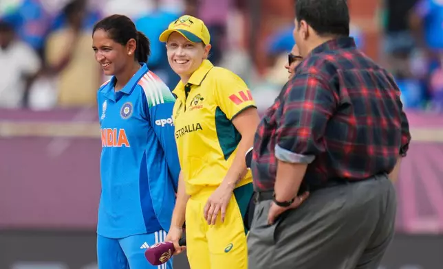 India's captain Harmanpreet Kaur, left, and Australia's captain Alyssa Healy at the coin toss ahead of the ICC Women's Cricket World Cup match between India and Australia at ACA-VDCA Cricket Stadium in Visakhapatnam, India, Sunday, Oct. 12, 2025. (AP Photo/Aijaz Rahi)
