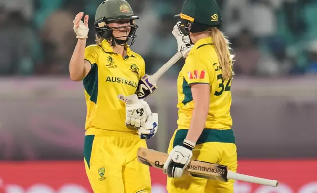 Australia's Ellyse Perry, left, and batting partner Kim Garth celebrate after their win in the ICC Women's Cricket World Cup match against India at ACA-VDCA Cricket Stadium in Visakhapatnam, India, Sunday, Oct. 12, 2025. (AP Photo/Aijaz Rahi)