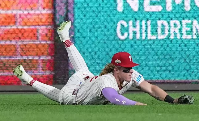 Philadelphia Phillies center fielder Harrison Bader catches a pop-foul out by Los Angeles Dodgers' Andy Pages during the fifth inning in Game 1 of baseball's National League Division Series, Saturday, Oct. 4, 2025, in Philadelphia. (AP Photo/Matt Rourke)