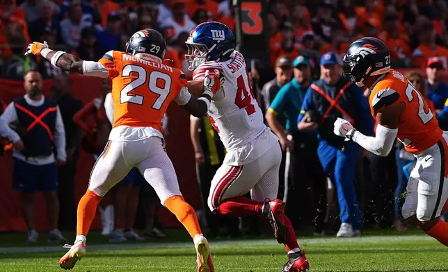 New York Giants running back Cam Skattebo (44) runs against Denver Broncos cornerback Ja'Quan McMillian (29) before scoring on the play during the first half of an NFL football game in Denver, Sunday, Oct. 19, 2025. (AP Photo/David Zalubowski)