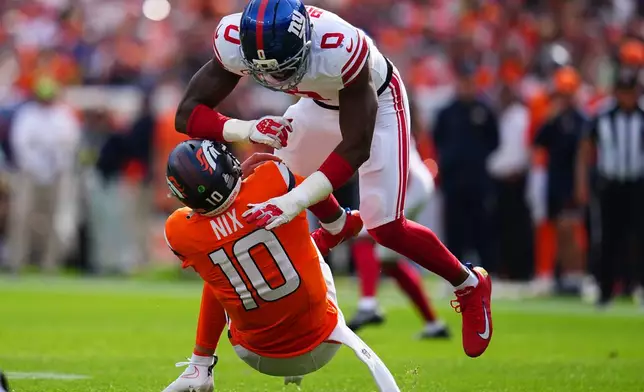 Denver Broncos quarterback Bo Nix (10) is sacked by New York Giants linebacker Brian Burns (0) during the first half of an NFL football game in Denver, Sunday, Oct. 19, 2025. (AP Photo/Jack Dempsey)
