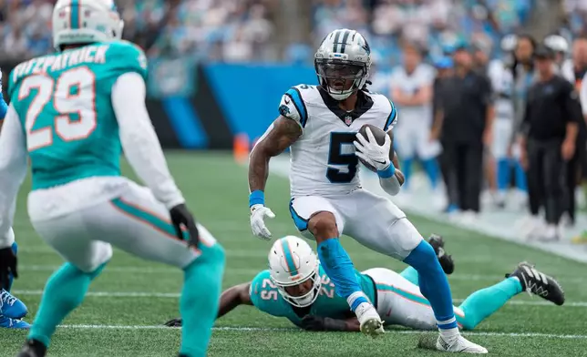 Carolina Panthers running back Rico Dowdle runs past Miami Dolphins linebacker Tyrel Dodson during the first half of an NFL football game, Sunday, Oct. 5, 2025, in Charlotte, N.C. (AP Photo/Jacob Kupferman)
