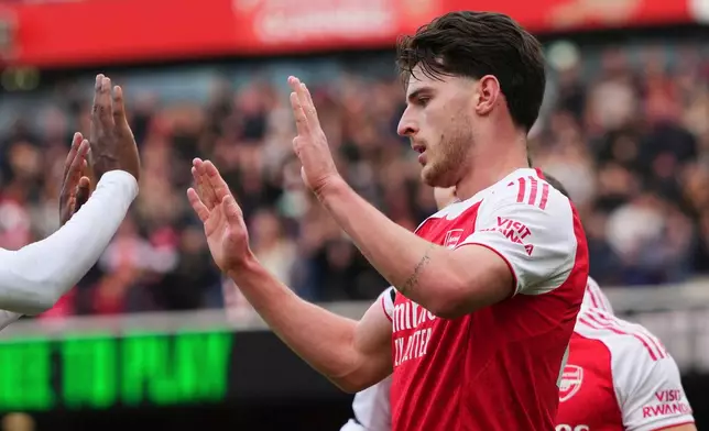 Arsenal's Declan Rice celebrates with teammates after scoring the opening goal during the substitution at the English Premier League soccer match between Arsenal and West Ham United at the Emirates stadium in London, Saturday, Oct. 4, 2025. (AP Photo/Kirsty Wigglesworth)