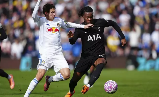 Leeds United's Brenden Aaronson, left, and Tottenham Hotspur's Destiny Udogie battle for the ball during the English Premier League soccer match at between Leeds United and Tottenham Hotspur at Elland Road, Leeds, England, Saturday Oct. 4, 2025. (Owen Humphreys/PA via AP)