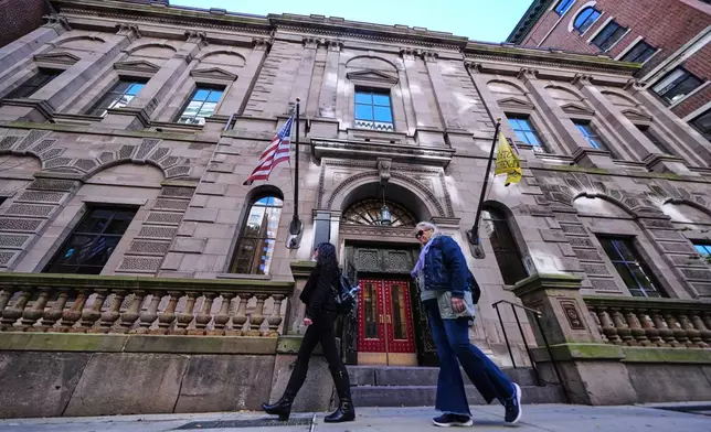 Two pedestrians walk past the Boston Athenaeum, one of the oldest independent libraries in the United States, Thursday, Oct. 9, 2025, in Boston. (AP Photo/Charles Krupa)