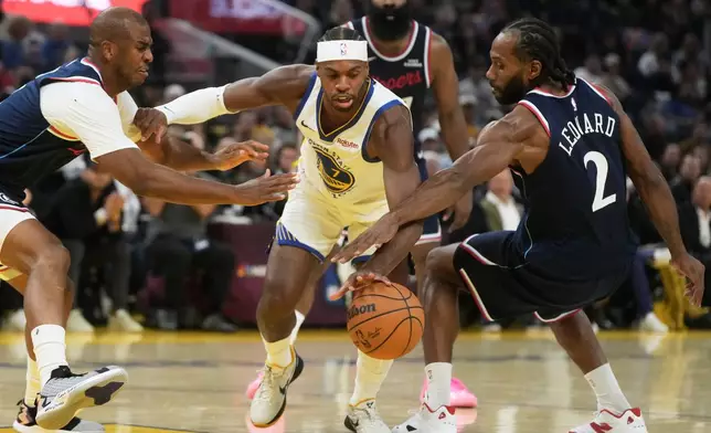 Golden State Warriors guard Buddy Hield, middle, reaches for the ball between Los Angeles Clippers guard Chris Paul, left, and forward Kawhi Leonard (2) during the first half of an NBA basketball game in San Francisco, Tuesday, Oct. 28, 2025. (AP Photo/Jeff Chiu)