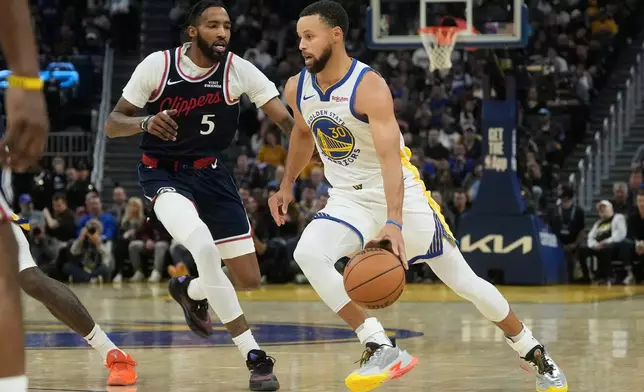 Golden State Warriors guard Stephen Curry (30) drives to the basket against Los Angeles Clippers forward Derrick Jones Jr. (5) during the first half of an NBA basketball game in San Francisco, Tuesday, Oct. 28, 2025. (AP Photo/Jeff Chiu)