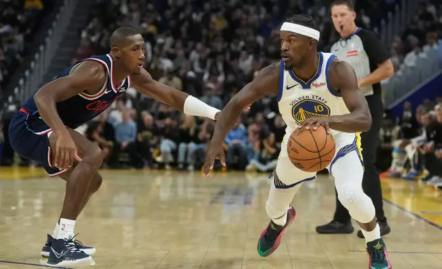 Golden State Warriors forward Jimmy Butler III (10) drives to the basket against Los Angeles Clippers guard Kris Dunn during the first half of an NBA basketball game in San Francisco, Tuesday, Oct. 28, 2025. (AP Photo/Jeff Chiu)