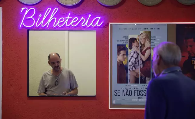 Carlos Costa sells movie tickets at his Cine LT3 in an old parking garage in Sao Paulo, Thursday, Oct. 9, 2025. (AP Photo/Ettore Chiereguini)