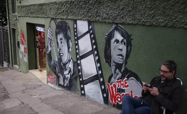 A man sits outside Cine LT3 cinema built in an old parking garage in Sao Paulo, Thursday, Oct. 9, 2025. (AP Photo/Ettore Chiereguini)