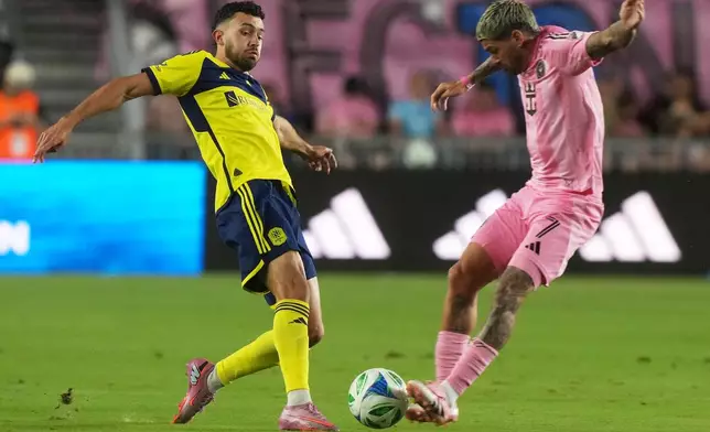 Inter Miami midfielder Rodrigo de Paul (7) blocks a pass by Nashville SC midfielder Patrick Yazbek (8) during the first half of match one of an MLS playoff opening round soccer match Friday,, Oct. 24, 2025, in Fort Lauderdale, Fla. (AP Photo/Marta Lavandier)