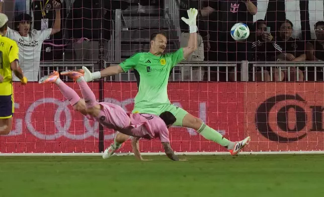 Inter Miami forward Lionel Messi (10) scores a goal against Nashville SC goalkeeper Joe Willis (1) during the first half of match one of an MLS playoff opening round soccer match Friday,, Oct. 24, 2025, in Fort Lauderdale, Fla. (AP Photo/Marta Lavandier)