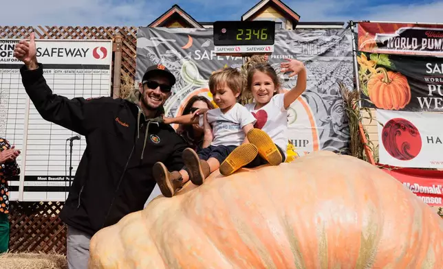 From left, Brandon Dawson celebrates with his children Roman and Ayla after winning the Safeway 52nd annual World Championship Pumpkin Weigh-Off in Half Moon Bay, Calif., Monday, Oct. 13, 2025. (AP Photo/Godofredo A. Vásquez)