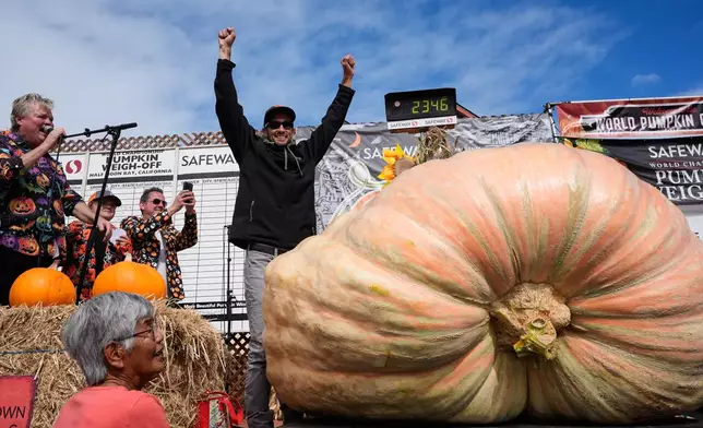 Brandon Dawson, center, celebrates after winning the Safeway 52nd annual World Championship Pumpkin Weigh-Off in Half Moon Bay, Calif., Monday, Oct. 13, 2025. (AP Photo/Godofredo A. Vásquez)