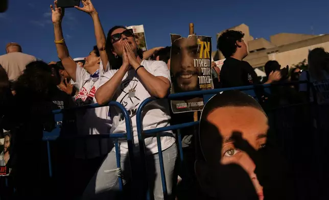 People gather to watch a live broadcast of Israeli hostages released from Gaza at a plaza known as hostages square in Tel Aviv, Israel, Monday, Oct. 13, 2025. The release took place as part of a cease-fire agreement between Israel and Hamas. (AP Photo/Oded Balilty)