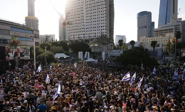 People gather to watch a live broadcast of Israeli hostages released from Gaza at a plaza known as hostages square in Tel Aviv, Israel, Monday, Oct. 13, 2025. The release took place as part of a cease-fire agreement between Israel and Hamas. (AP Photo/Oded Balilty)