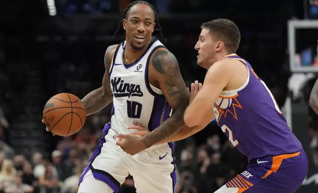 Sacramento Kings guard DeMar DeRozan (10) shields the ball from Phoenix Suns guard Collin Gillespie during the first half of an NBA basketball game, Wednesday, Oct. 22, 2025, in Phoenix. (AP Photo/Rick Scuteri)