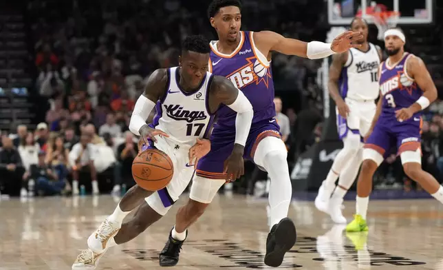 Sacramento Kings guard Dennis Schroder (17) drives past Phoenix Suns guard Ryan Dunn during the first half of an NBA basketball game, Wednesday, Oct. 22, 2025, in Phoenix. (AP Photo/Rick Scuteri)