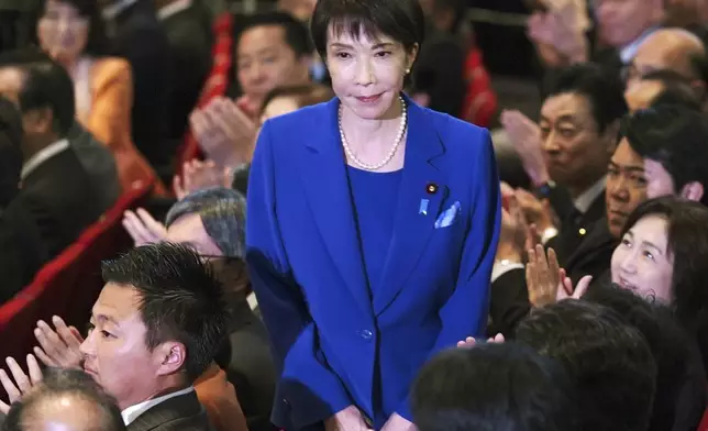 Former Economic Security Minister Sanae Takaichi, center, stands as Takaichi was chosen to a new leader of Japan’s ruling Liberal Democratic Party during the party's leadership election in Tokyo, Japan, Saturday, Oct. 4, 2025. (Yohei Fukai/Kyodo News via AP)
