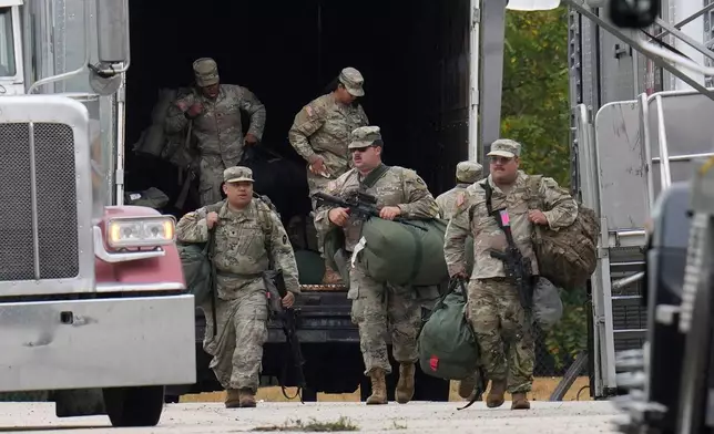 Military personnel in uniform, with the Texas National Guard patch on, are seen at the U.S. Army Reserve Center, Tuesday, Oct. 7, 2025, in Elwood, Ill., a suburb of Chicago. (AP Photo/Erin Hooley)