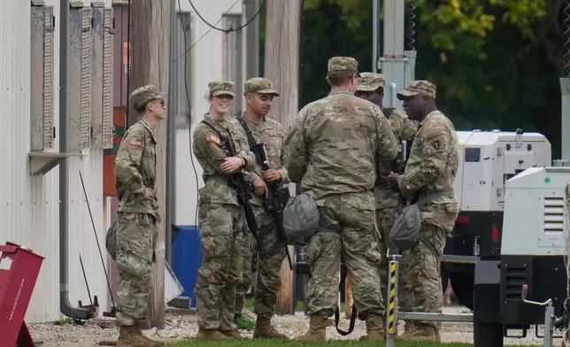Military personnel in uniform, with the Texas National Guard patch on, are seen at the U.S. Army Reserve Center, Tuesday, Oct. 7, 2025, in Elwood, Ill., a suburb of Chicago. (AP Photo/Erin Hooley)