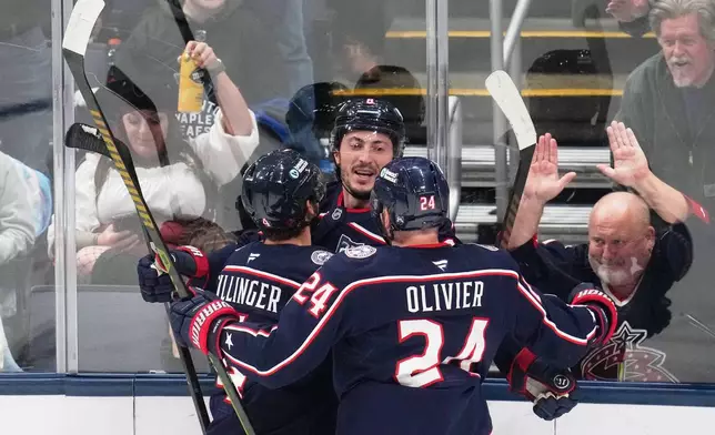 Columbus Blue Jackets defenseman Zach Werenski, center, celebrates his goal with teammates Cole Sillinger, left, and Mathieu Olivier (24) in the first period of an NHL hockey game against the Toronto Maple Leafs in Columbus, Wednesday, Oct. 29, 2025. (AP Photo/Sue Ogrocki)